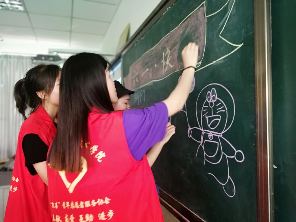 志愿者带领孩子们绘制主题板报