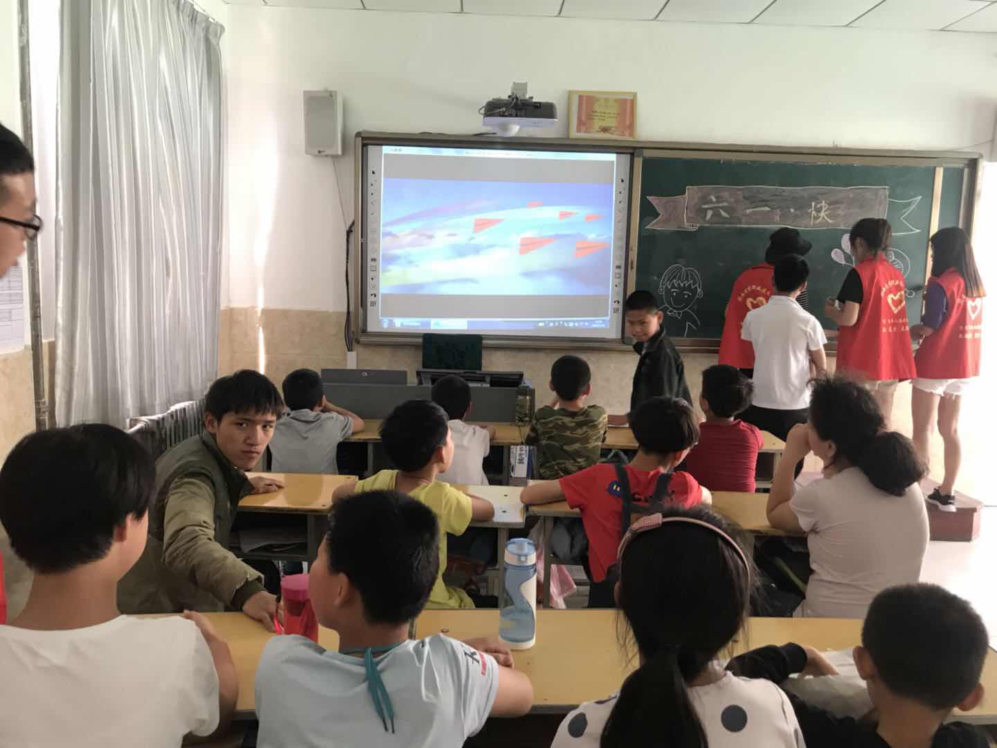 志愿者带领孩子们观看纪录片《厉害了我的国》